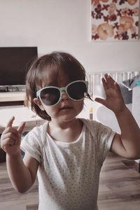 Portrait of cute girl holding sunglasses