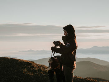 Woman standing on mountain against sky