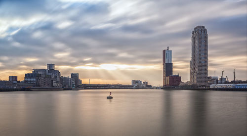 View of buildings in city against cloudy sky