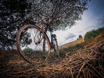 Bicycle wheel on field against sky