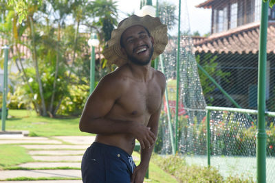 Portrait of happy man in hat standing outdoors