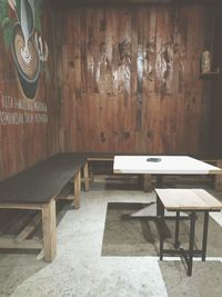 Empty chairs and table against wall in building