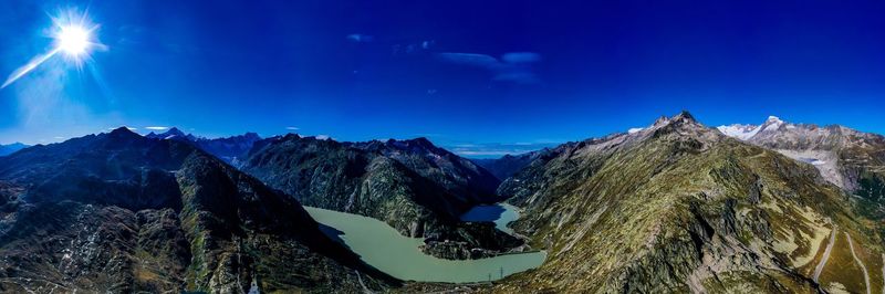 Panoramic view of snowcapped mountains against blue sky