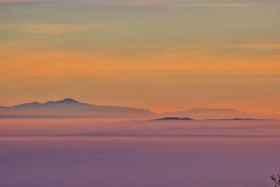 Scenic view of mountains against sky at sunset