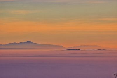 Scenic view of mountains against sky at sunset