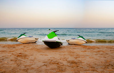 Boat moored on beach against sky