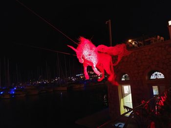 Low angle view of illuminated toy against sky at night