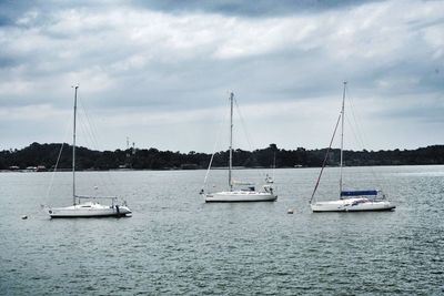 Boats sailing on sea against sky