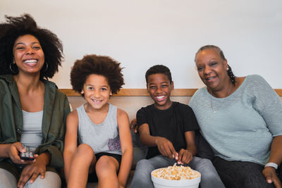 Portrait of smiling family sitting on sofa at home