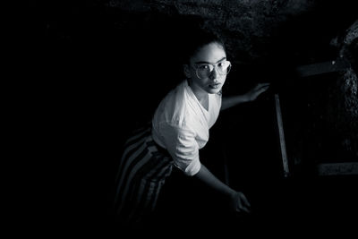 High angle portrait of young woman sitting in darkroom