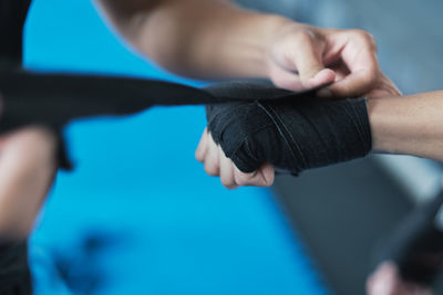 Friend tying bandage on players hand at gym