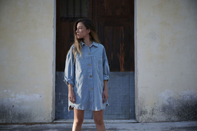 Full length of woman standing against wall