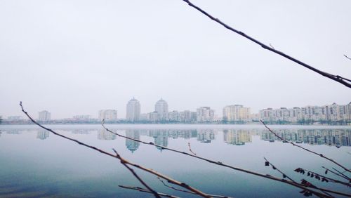 Scenic view of lake by city against sky