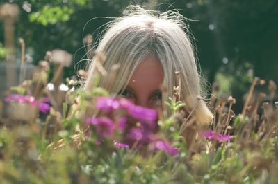 Portrait of woman hiding behind plants