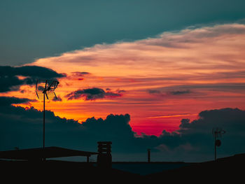 Silhouette street light against orange sky