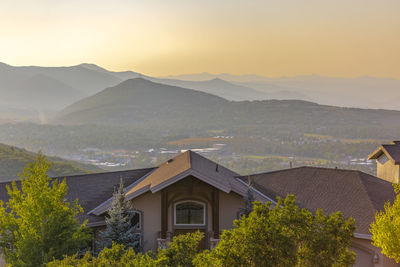 Houses and mountains against sky during sunset