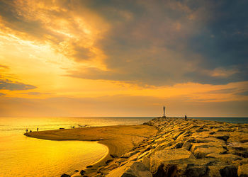 Scenic view of beach against sky during sunset