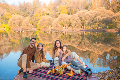 Group of people sitting at park during autumn