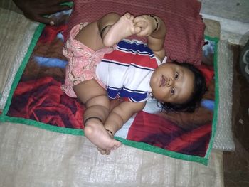 High angle view of baby lying on bed