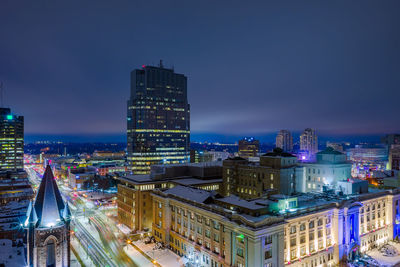 Illuminated buildings in city against sky at night