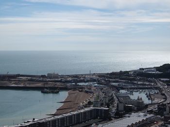 High angle view of city by sea against sky