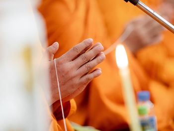 Close-up of monk praying with hands clasped