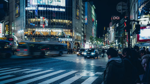 People crossing road in city at night