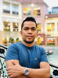 Portrait of young man standing in city