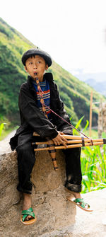 An ethnic minority child in ha giang, vietnam, playing khèn.