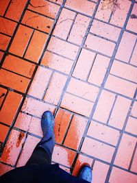 Low section of man walking on wet footpath