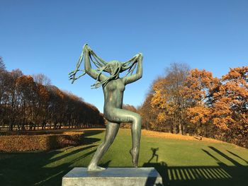 Statue in park against clear blue sky