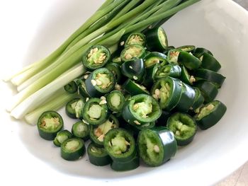 High angle view of celery with green chili peppers on bowl