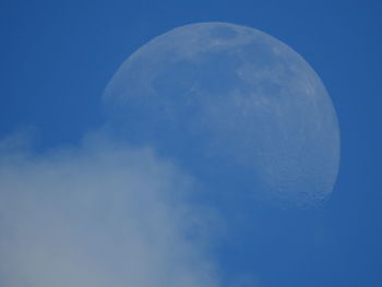 Low angle view of moon against blue sky