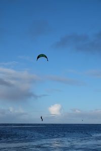 Man parasailing over sea against sky