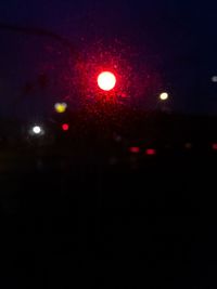 Close-up of illuminated lights against sky at night