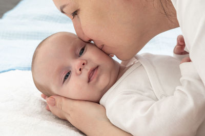 Close-up of mother and daughter on bed at home