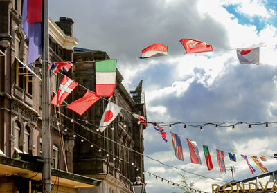 Low angle view of flags hanging against sky