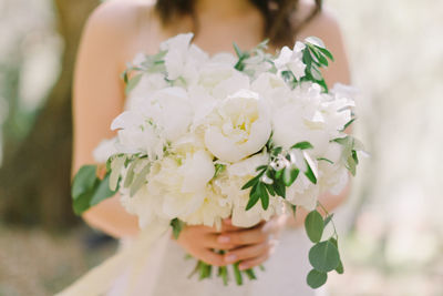 Close-up of woman holding white flowering plant