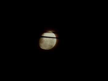 Close-up of illuminated lamp against dark sky