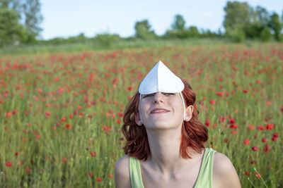 Portrait of young woman standing on field