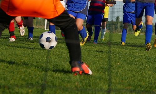 Low section of players playing on soccer field