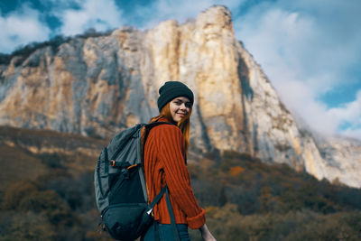 Young woman standing on rock against mountains