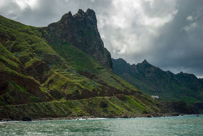 Scenic view of sea and mountains against sky