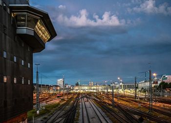 Railroad tracks amidst buildings in city against sky