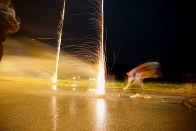 Light trails on road against sky at night