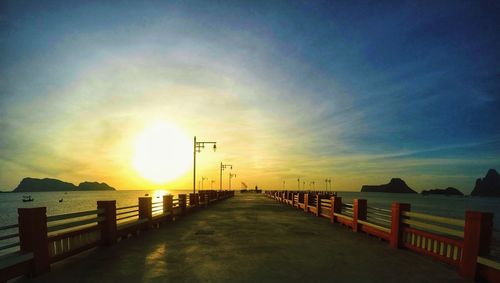 Pier over sea against sky during sunset