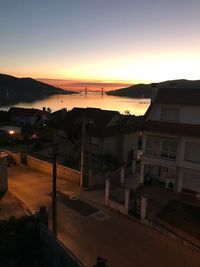 High angle view of street by buildings against sky during sunset