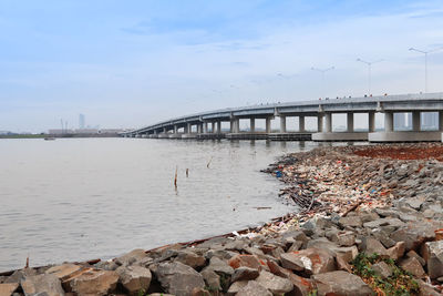 Bridge over river in city against sky