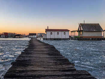 Pier by sea against sky during sunset