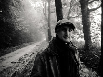 Portrait of young man standing in forest